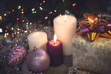 Yanan mumlar, Noel süsleri ve bir hediye kutusu ile natürmort