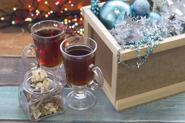 A wooden box with ornaments and two cups of tea