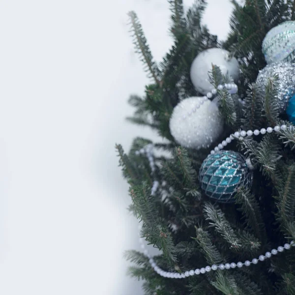 Beyaz, gümüş ve mavi baubles bir Noel ağacı üzerinde