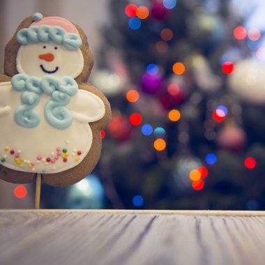 Ahşap bir masa süslü Noel ağacına bir gingerbread kardan adam