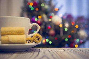 Bir çay bardağı ile dekore edilmiş Noel ağacına ahşap bir masa tanımlama bilgilerini