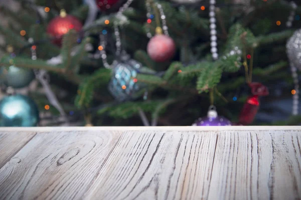 Wooden table against decorated Christmas tree — Stock Photo, Image