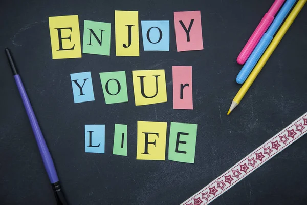 Geniet van uw leven inscriptie op een schoolbord — Stockfoto