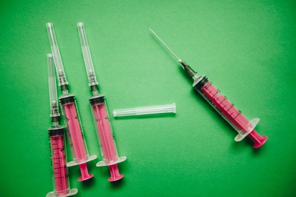 Zelené pozadí s injekční stříkačky — Stock fotografie