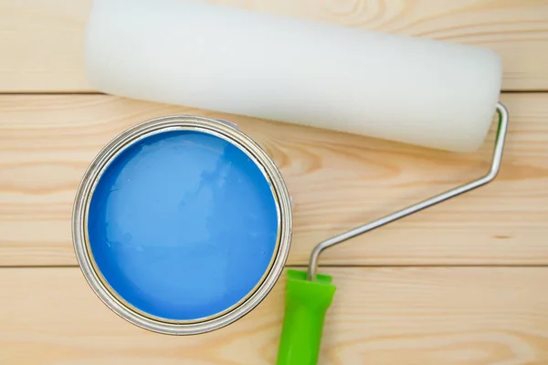 Uma lata de tinta azul e um rolo de tinta — Fotografia de Stock