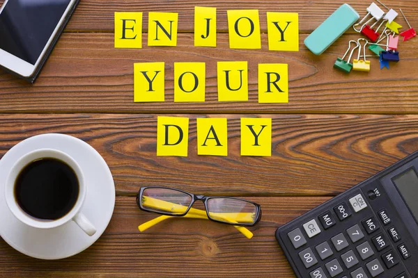 Enjoy your day inscription on wooden table.