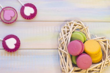 Ahşap arka plan üzerinde macaroons ile dokuma kalp