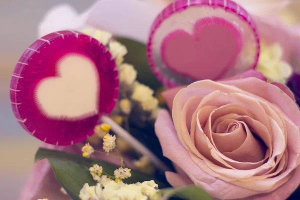 Una cesta de flores y caramelos lolipop — Foto de Stock