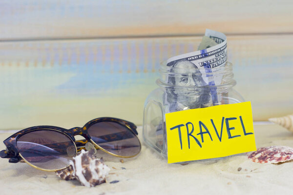 Planning for vacation, saving money for next trip. Swimming glasses on sand background