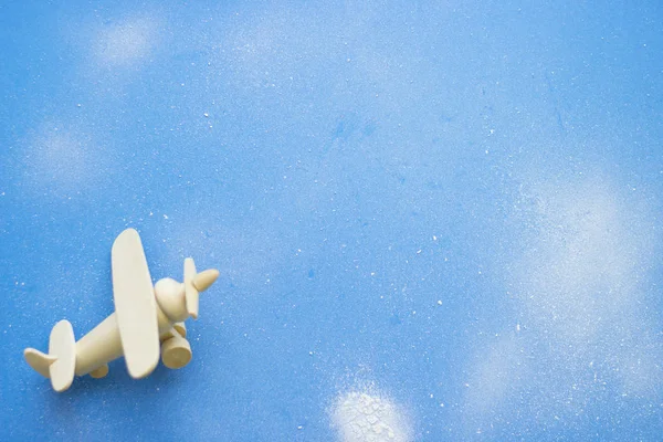Blue powdered background with toy airplane