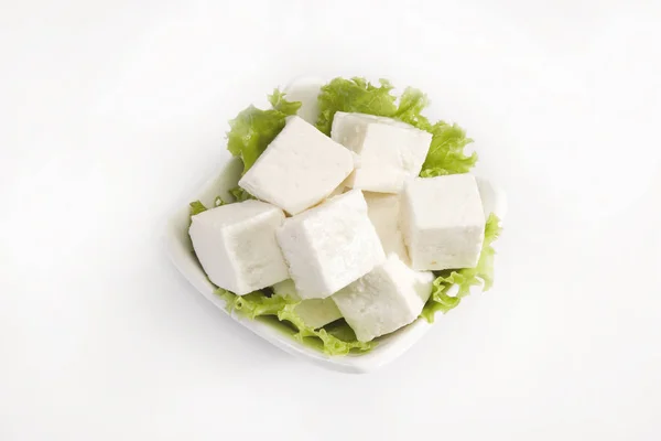 Pezzo di formaggio o Paneer isolato su uno sfondo bianco Immagine Stock