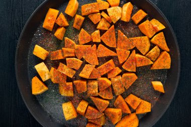 bir yuvarlak pişirme üzerinde baharatlar ile ham dilimlenmiş kabak