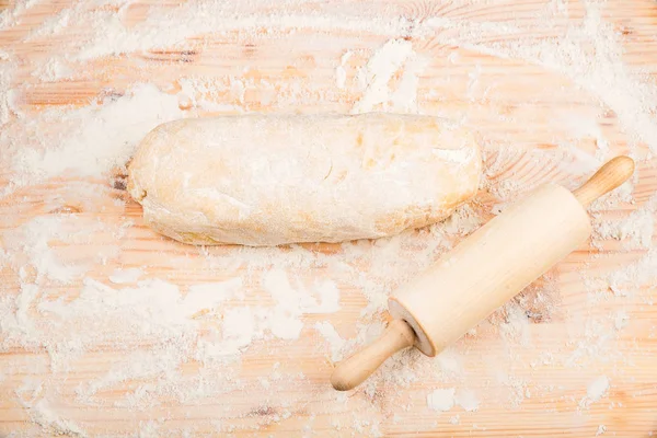 Massa de farinha de cozinha em uma mesa de madeira — Fotografia de Stock