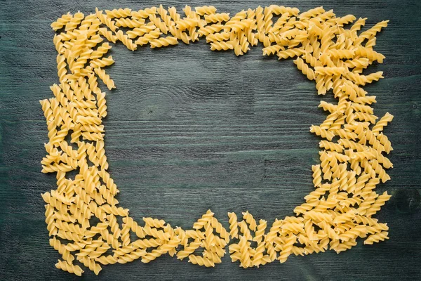 Makarna çerçeve koyu ahşap bir masa üzerinde. Arka plan