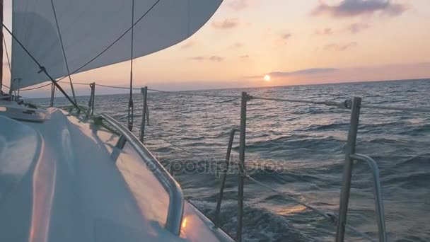 Sidovy av segelbåt näsa och vacker rosa solnedgång. Yacht gungande havet vågor på solnedgången. Romantiska — Stockvideo