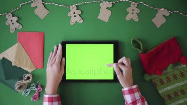 Noel tatil tablo üstten görünüm kavramı. Kaydırma, swiping, yeşil ekran tablet cihaz üzerindeki yakınlaştırma parmak. Chroma anahtar