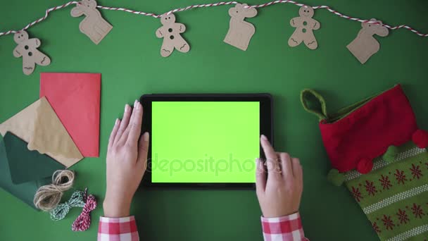 Table top view from above. Woman zooming image, taping on tablet green screen. Chroma key. Christmas concept — Stock Video