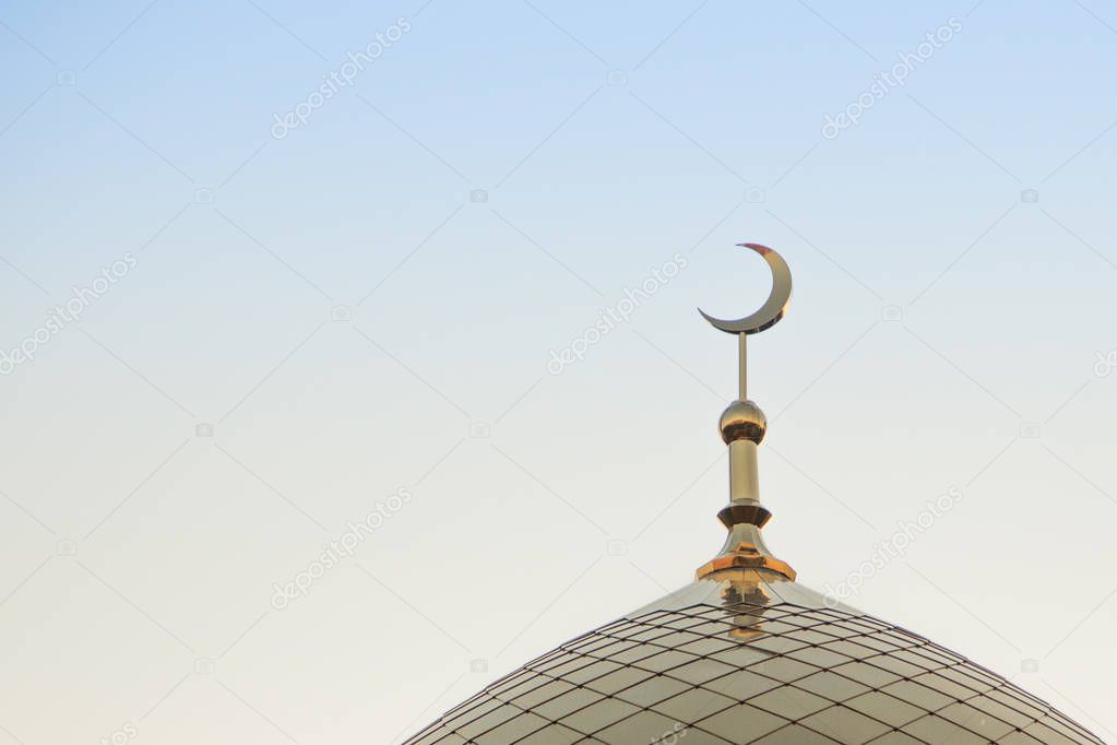 The top of the golden minaret with the symbol of Islam is the growing moon of the golden crescent moon. Right in the frame.