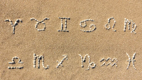 Astrological signs of the zodiac laid out of stones on the sand of the sea shore. — Stock Photo, Image