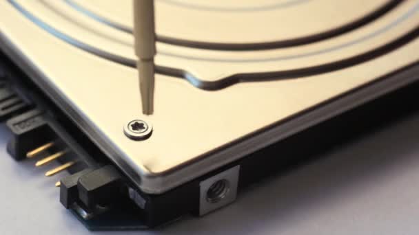 Close-up. The screwdriver unscrews the screw from the computer hard drive. — Stock Video