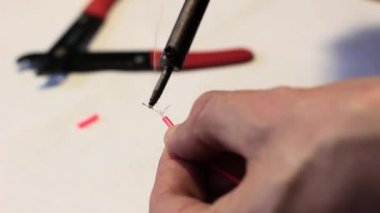 Lehimleme telleri kırmızı bir kabuk ile bir adam. Yakın çekim.