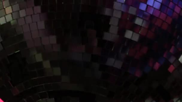 The mirror ball is close-up, which reflects the multi-colored light in the nightclub. — Stock Video