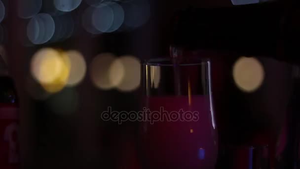 Iemands hand giet een mousserende wijn in een glas in de donkere kamer van een nachtclub. — Stockvideo