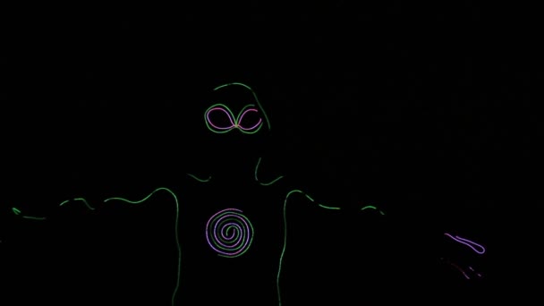 Dance is glowing in the dark neon outline of an alien. — Stock Video