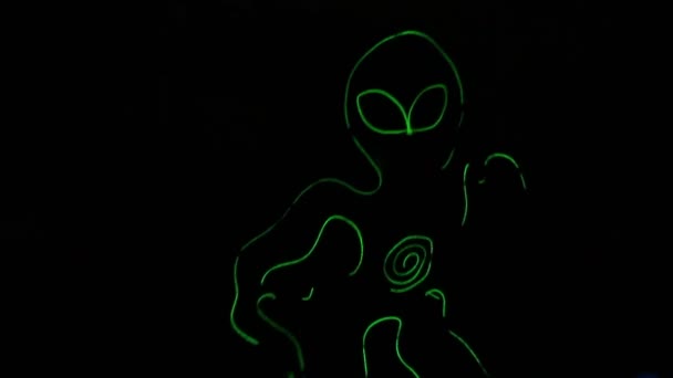 Un adolescent dans le costume lumineux d'un extraterrestre dans les danses sombres dans le style d'un hiphop et tourne un poi . — Video