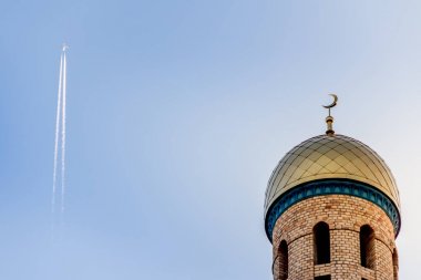 Müslüman Minare Camii kadar uçan uçak ile mavi gökyüzüne karşı.