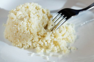 Yemek menüsü için. Beyaz haşlanmış pirinç ve metal çatal beyaz bir plaka üzerinde.