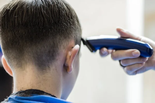 Corte de cabelo na cabeça de um adolescente em um cabeleireiro . — Fotografia de Stock