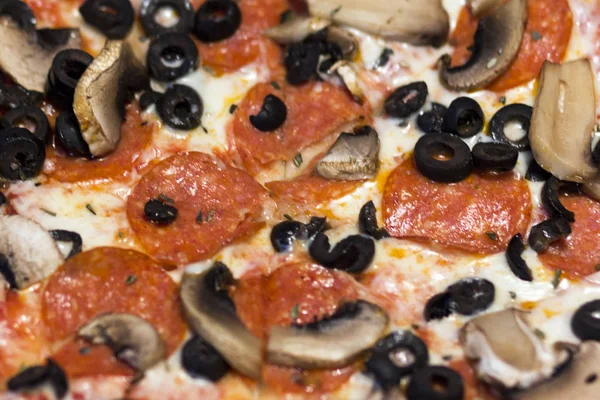 Bakgrund av pizza närbild: korv, oliver, champinjoner, ost. — Stockfoto