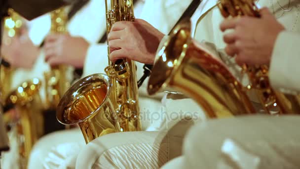 Saxophonists in white suits play a jazz part. Small DOF. — Stock Video