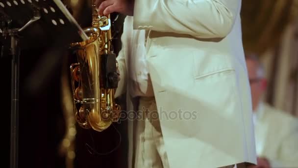 Le saxophoniste en costume blanc joue seul sur un saxophone . — Video