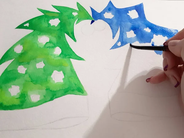 Flickans hand ritar en blå och gröna fir-träd med en akvarell färg — Stockfoto