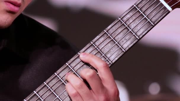 Un uomo sta suonando la chitarra. Un primo piano della mano sinistra che mette gli accordi sulla tastiera. Un uomo sta suonando la chitarra . — Video Stock