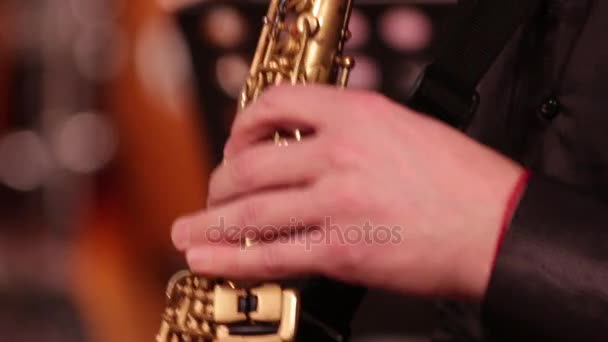 Bir tahta Nefesli/Üflemeli Saz soprano saksofon çalıyor. Yakın çekim. Müzisyen anahtarları sıkma tarafından müzik sesleri alır ve oyun sona erer. — Stok video
