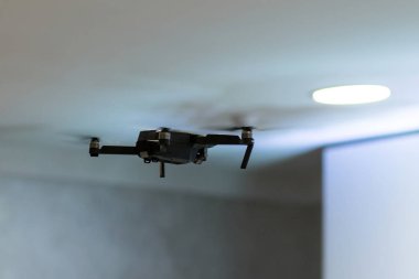 İdari Binası koridorunda tavan altında bir siyah radyo kontrollü pilotsuz bir video kamera ile uçar.