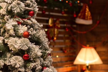 Yeni yıl arka plan bulanık. Ön ve parlayan bir masa lambası arka planda üzerinde Santa Claus şapka şenlikli bir Noel ağacı.