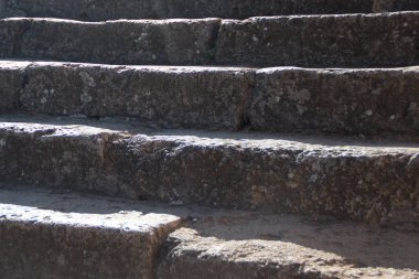 Güneş tarafından aydınlatılmış eski taş basamaklar.