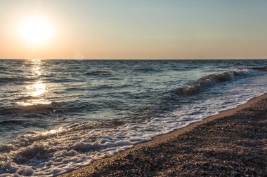 Kabukları ile sahilinde günbatımı, dalgalar deniz. Güzel arka plan.
