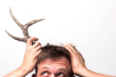 The man with surprise holds on to the horn on his head. clipart