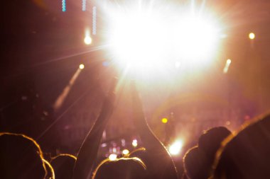 Hayranları bir rock konserinde güzel altın ışıkları açık havada ellerini sallıyorsun.