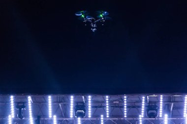 Konser sahne ışıkları üzerinde karanlık gökyüzünde video casus uçak.