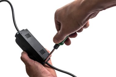 Adam vida güç kaynağı ünitesi üzerinde bir tornavida ile döner.