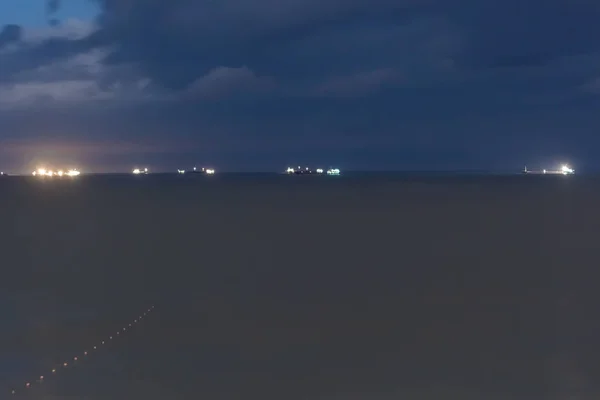 Światła statków handlowych na horyzoncie morze we mgle wieczorem. — Zdjęcie stockowe