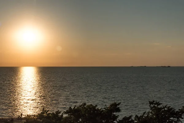 Pôr do sol no mar, no horizonte você pode ver navios de comércio de carga ou barcaças . — Fotografia de Stock