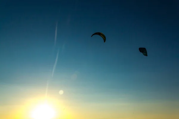 Deux cerfs-volants pour surfer en l'air contre le coucher du soleil . — Photo