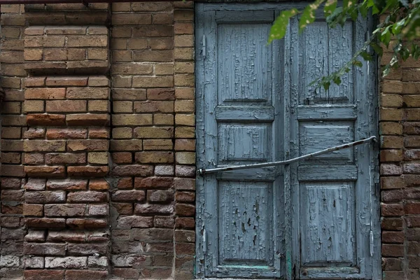 The old window is covered with blue shutters on a vintage brick wall. — Stock Photo, Image